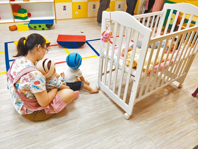 全台疫情警戒将在7月27日起降至2级，疫情指挥中心有条件开放托婴中心及居家保母收托。图为居家保母照顾小孩的画面。（本报资料照片）