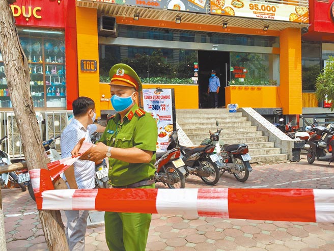 东南亚国家越南的新冠疫情已由南部重灾区往北扩散，首都河内市宣布24日起第3次「封城」，为期15天。图为先前河内再现本土病例，警察封锁1名确诊患者工作过的比萨店。（新华社）