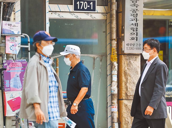 韓國國會24日凌晨通過「第5次災難支援金」的紓困提案，約88％的民眾每人可領25萬韓元。圖為戴口罩的市民走在首爾的街道上。（新華社）