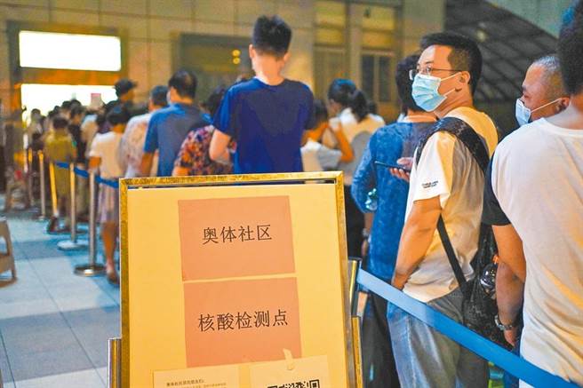 大陸南京新冠疫情上升，今（26日）新增38例本土病例。圖為南京居民21日排隊準備進行核酸檢測。（新華社）