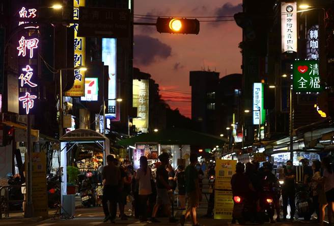 三级警戒27日起降至二级，26日晚间台北市华西街周遭夜市微解封试营运，入口设置一个自动化消毒门，所有进出民眾都要实名制也要量额温、消毒才能进入夜市。（邓博仁摄）