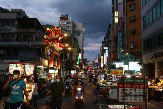 三级警戒27日起降至二级，26日晚间台北市华西街周遭夜市微解封试营运，入口设置一个自动化消毒门，所有进出民眾都要实名制也要量额温、消毒才能进入夜市。（邓博仁摄）