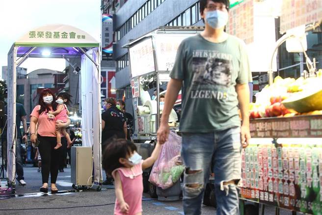 三级警戒27日起降至二级，26日晚间台北市华西街周遭夜市微解封试营运，入口设置一个自动化消毒门，所有进出民眾都要实名制也要量额温、消毒才能进入夜市。（邓博仁摄）
