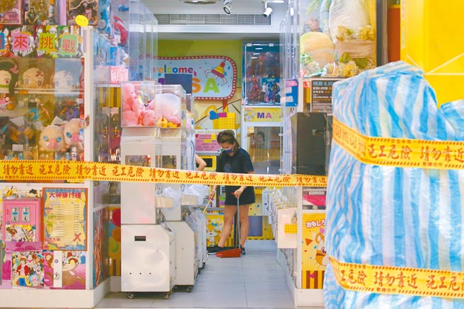 政府当务之急是赶快把救命钱交到民眾手上，但行政院还以「效益评估」为由，宣称还得再规画，而且打算採发放振兴券方式，而非普发现金。图为双北市因疫情考量仍禁止营业，台北市夹娃娃机业者趁假日打扫店面，期盼能早日营业。（陈君玮摄）