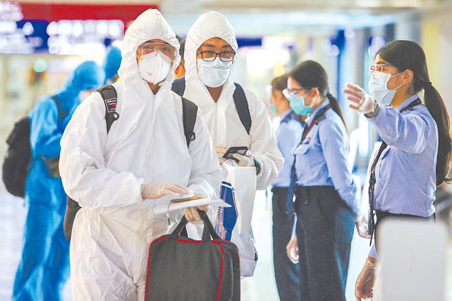 全台27日起将从三级警戒降至二级，疫情指挥中心25日公布新增12例本土案例。图为桃园机场旅客穿着全身防护衣入境。（陈麒全摄）