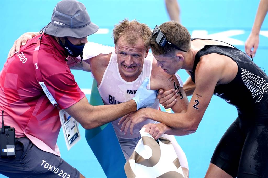 东奥铁人三项挪威金牌得主布鲁门菲特（Kristian Blummenfelt）26日在越过终点线后体力透支倒地，需要旁人搀扶。（图／美联社）(photo:ChinaTimes)