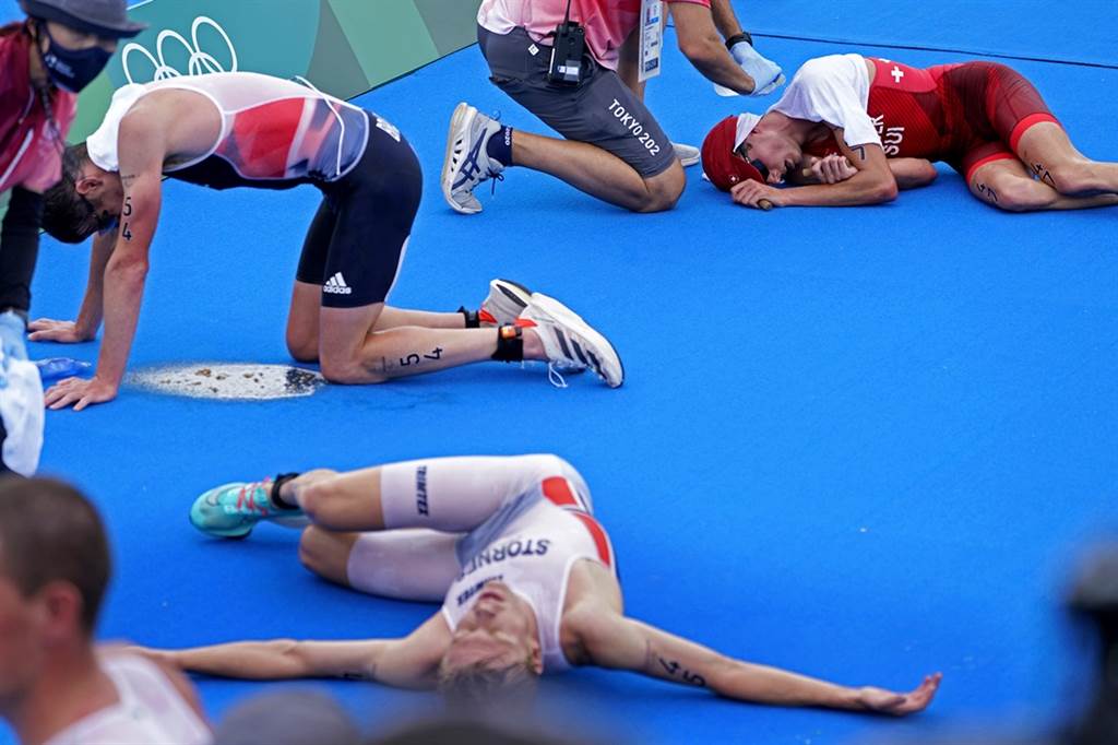 26日各国好手完成东奥铁人三项赛事后，体力透支倒地。（图／美联社）(photo:ChinaTimes)