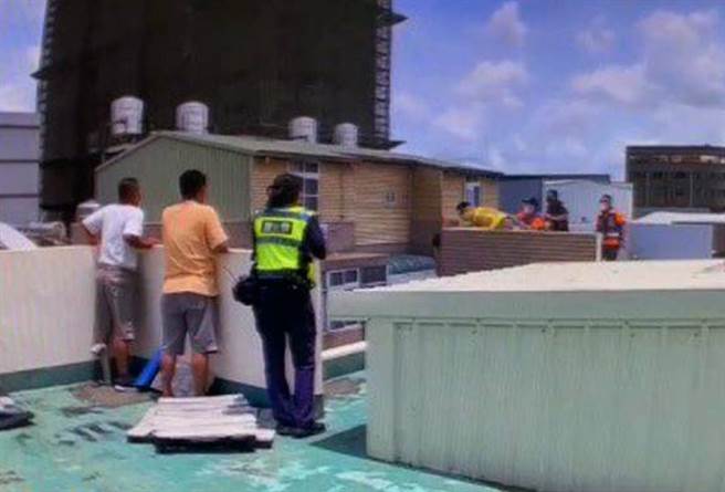 台南市永康區1名男子持水果刀坐自家頂樓女兒牆邊，消警人員先安撫對方情緒，再趁他不注意之際合力壓制救下送醫。（讀者提供／洪榮志台南傳真）