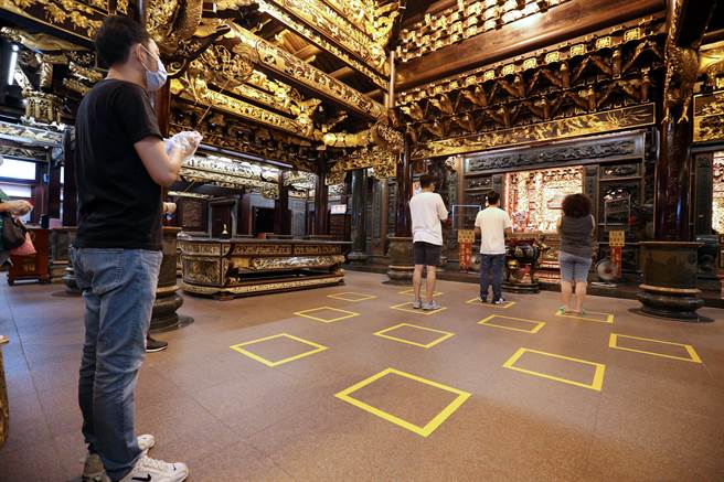 新北市中和烘爐地土地公廟27日零時起重新開放正殿供民眾參拜，廟方在地上貼顯目方框，提醒民眾遵守社交距離。（黃世麒攝）