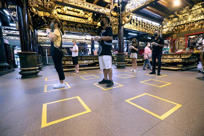 新北市中和烘爐地土地公廟27日零時起重新開放正殿供民眾參拜，廟方在地上貼顯目方框，提醒民眾遵守社交距離。（黃世麒攝）