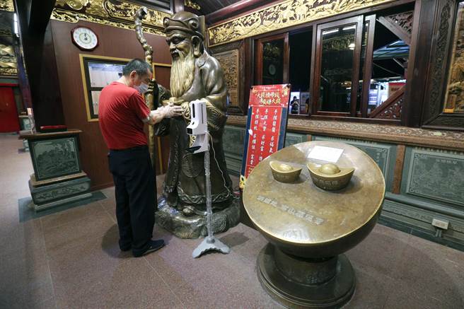 廟方也準備拋棄式手套，開放民眾碰觸土地公像及元寶，但不開放擲筊及求取籤詩。（黃世麒攝）