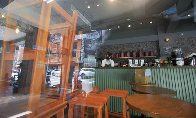 中央宣布27日全国疫情警戒降为二级，但双北市仍禁止餐厅内用，台北市长柯文哲日前抛出最快8月9日可开放户外餐厅内用，对此，新北市长侯友宜则强调是否开放餐饮内用，还是要看这周观察期的数据来考量，大稻埕码头附近的咖啡店内，桌椅堆迭在旁许久。（张铠乙摄）
