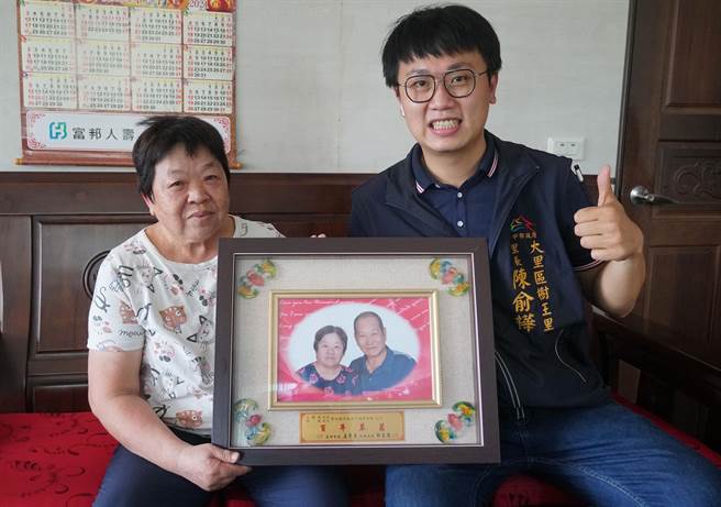 大里树王里民邱珠女士（左）与先生王锦鸿结婚50周年时未受邀表扬大会，经里长陈俞桦（右）争取，补受邀表扬大会，当时拍的金婚照，成为邱珠女士永恒的怀念。（黄国峰摄）