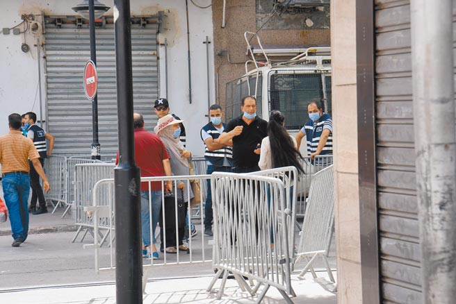 突尼斯警察封锁首都突尼斯市中心路口并查验路人身份。（新华社）