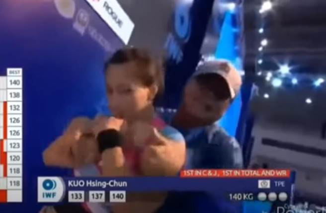 夺金后的场下镜头，郭婞淳被教练林敬能从后环抱，看着镜头摆出超萌姿势与表情。（截自YouTube画面）