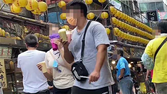 游客因为口渴，将口罩向上拉喝饮料。（读者提供／陈彩玲基隆传真）