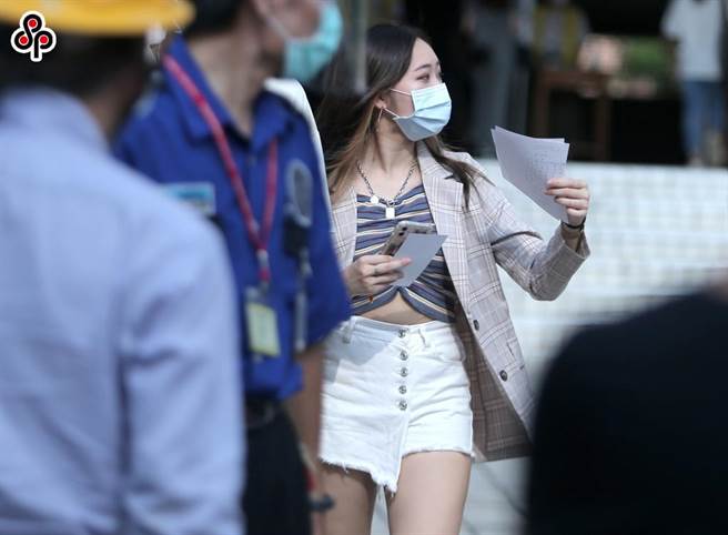 大學指考第二日繼續舉行，位於北市西松高中的考場外，一位打扮入時的考生，手上拿著考題資料走出校門。(粘耿豪攝)