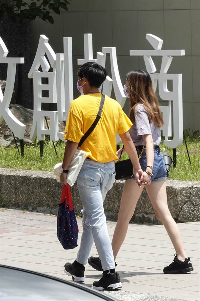 学生情侣大方牵手进出校园。（黄子明摄）