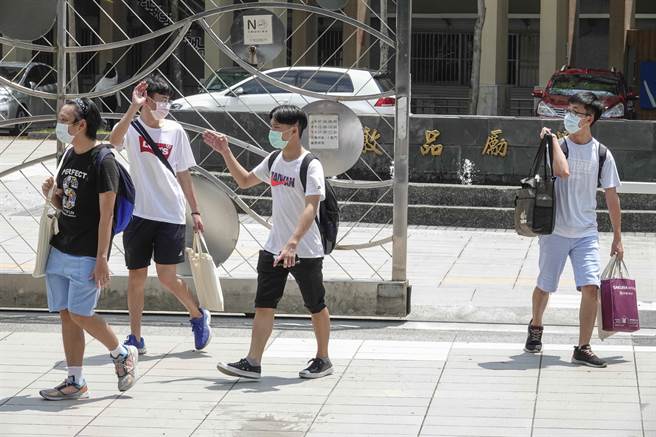 学生带着个人物品走出校门，挥手互道珍重再见。（黄子明摄）