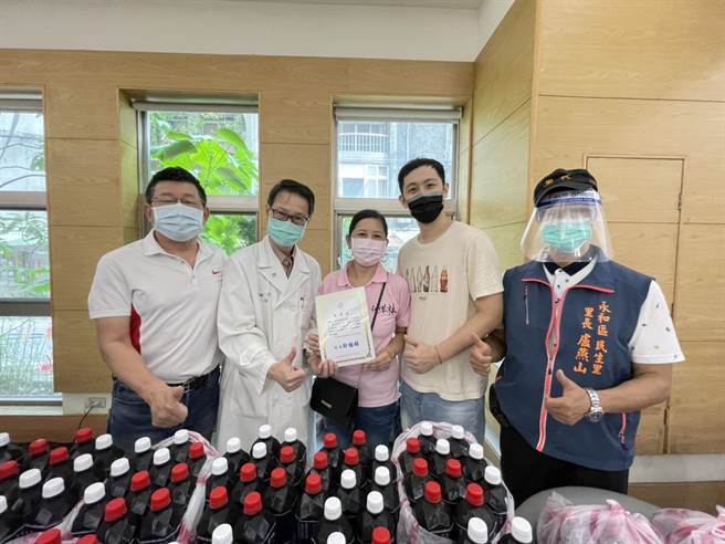 「仙草林」老闆林淼輝與妻子許秀卿、兒子今（29日）上午由副議長陳鴻源、民生里長盧燕山等陪同，帶著自製的200份仙草汁、仙草凍前往永和耕莘醫院，感謝醫護疫情間的付出。（葉書宏攝）