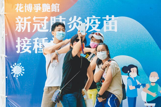 指挥官陈时中喊出，10月疫苗涵盖率希望达6成，但他表示有三大难题，施打意愿、接种的量能、以及疫苗进货的时程。图为北市花博接种站28日持续为国高中教职人员施打疫苗，多名教职员接种后开心卷起袖子自拍。（郭吉铨摄）