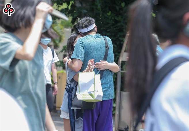 大學指考中午休息時分，位於中山女中的考場外，一位女性考生與前來送餐的男友互相擁抱，完全無視其他人。(示意圖，粘耿豪攝)