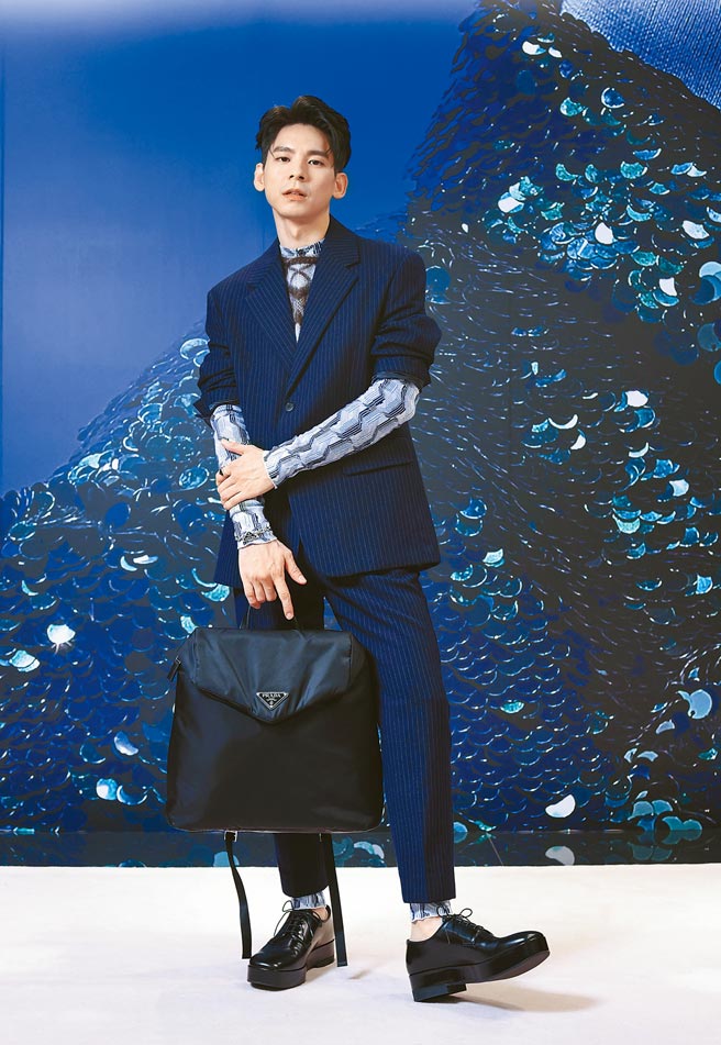 林柏宏出席Prada秋冬記者會，身穿Prada條紋西裝外套10萬5000元、幾何圖紋馬海毛背心3萬4000元、幾何圖紋連身褲8萬2000元、條紋長褲4萬500元、繫帶皮鞋4萬500元、三角標誌手鍊2萬7500元、三角標誌戒指2萬3500元、再生尼龍後背包5萬2000元。（Prada提供）