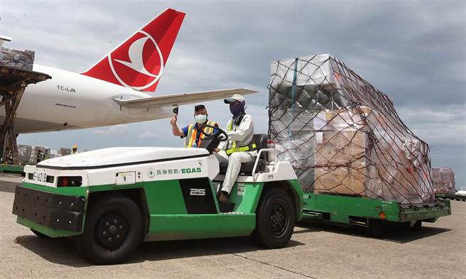 1名負責載運裝有疫苗貨盤的地勤人員，開心地舉手比讚。（范揚光攝）
