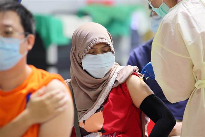 不少民眾飞到国外打疫苗，返国时希望可放宽14天在检疫旅馆的时间。对此，中央疫情指挥中心31日指出，目前并没有打算要放宽，还是有打了两剂BNT疫苗返国染疫的民眾，还是要严防delta病毒，31日到北市花博接种站施打疫苗的民眾，其中不乏外籍人士。（张铠乙摄）
