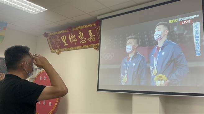 「麟洋配」拿下金牌，颁奖现场响起国旗歌。杨镇浯县长也举手致敬，分享荣耀的一刻。（县府提供）