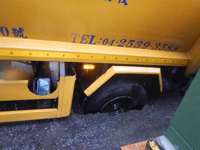 一辆垃圾车今早在台中市政和路上静止状态，正要收路旁垃圾箱，左后车轮处地面突塌陷。（民眾提供／卢金足台中传真）