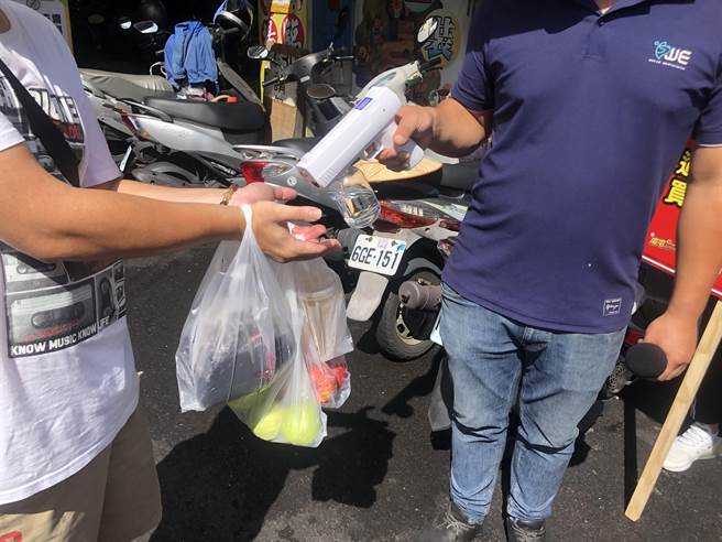 民眾伸出手喷酒精，保护自己也家人。（「南屯即时通」粉专提供）