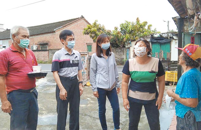 水保局南投分局长陈荣俊（左二）日前在蚵寮社区理事长林东言（左一）、总干事陈玉钗（右二）陪同下，到四湖乡蚵寮村送餐。（农委会水土保持局提供／周丽兰云林传真）