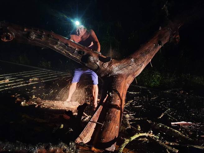 埔里警分局員警連夜冒雨鋸除倒伏樹木，確保交通安全。（埔里警分局提供／廖志晃南投傳真）