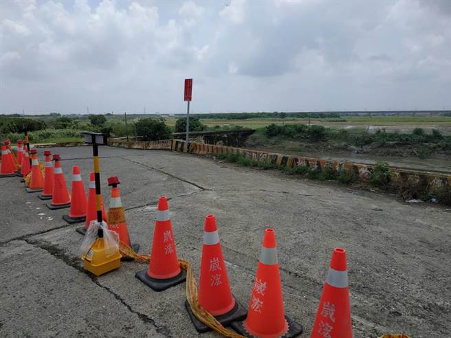 雲林縣北港溪北港鎮段的水位仍未完全消退，警方封鎖後溝橋、勸導河床住戶。（張朝欣攝）