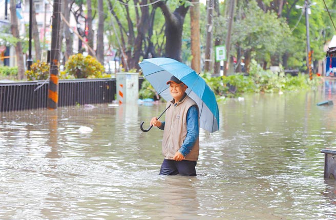 嘉义县新港乡2日累积雨量逾300毫米，奉天宫前中山路一带积淹水严重，水深一度达到成人的大腿高度，让居民也不禁苦笑。（吕妍庭摄）