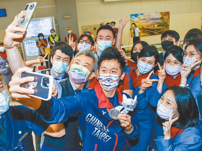 「鞍马王子」李智凯3日光荣返台，受到地勤人员热烈欢迎，纷纷要求合照，李智凯（中）也拿出手机自拍。（陈麒全摄）