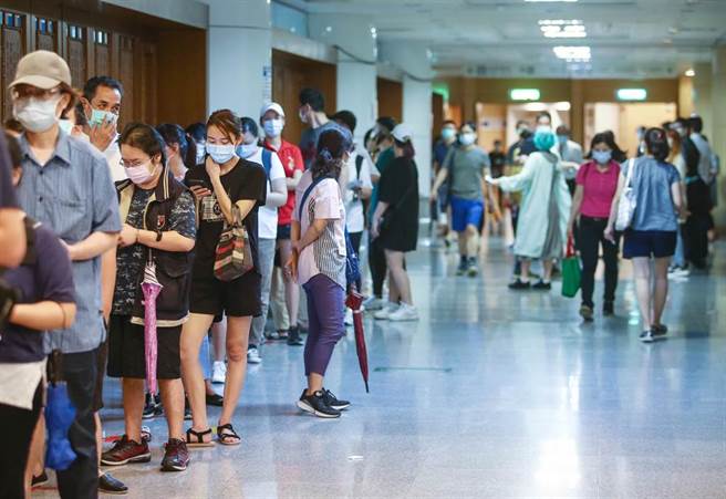 指挥中心日前已配送52.57万剂的AZ疫苗供地方政府提供疫苗预约平台、国高中教师及补教业者接种。新店慈济医院配合新北市政府在院内设立的施打站，5日预约接种人数共有1千人，注射疫苗前民眾排队让医护人员量额温及核对资料。（邓博仁摄）
