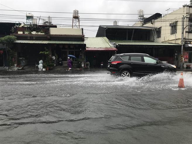 大仁科大前维新路段，水淹小腿肚、积水不退，附近居民出入不仅得涉水而行，还要忍受汽机车行驶时溅起的大水花，住户苦不堪言。（谢佳潾摄）