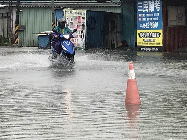 大仁科大前维新路段，水淹小腿肚、积水不退，附近居民出入不仅得涉水而行，还要忍受汽机车行驶时溅起的大水花，住户苦不堪言。（谢佳潾摄）