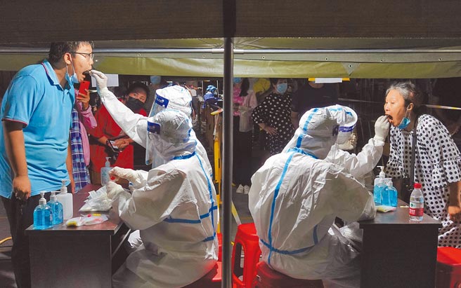 大陆本土疫情呈现多点爆发，山东烟台启动主城区全员核酸检测，医务人员为市民进行核酸检测取样。（新华社）