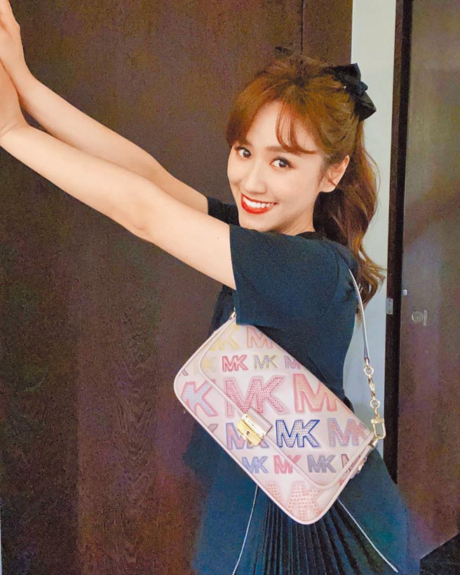 吴姗儒以低调的墨水蓝洋装搭配七彩的Michael Kors七夕胶囊包款。Bradshaw肩背包，2万2500元。（Michael Kors提供）