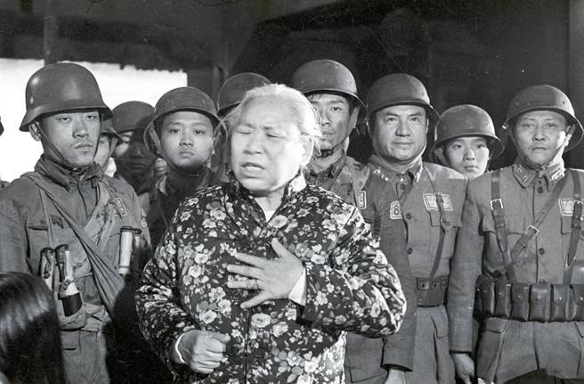 1975年，中影拍摄「八百壮士」影片时，抗战期间在上海向四行仓库孤军献旗的女童军杨惠敏忆述当时的情形，饰演国军的演员细心听讲。(邱维国摄)