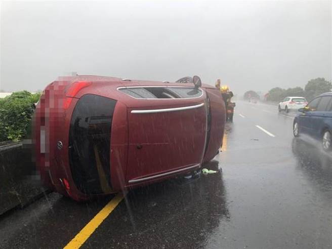 １輛百萬紅色轎車今晨7時許，行經國道1號北上208.3K時，疑失控打滑自撞護欄90度翻覆。（圖／彰化縣消防局提供）