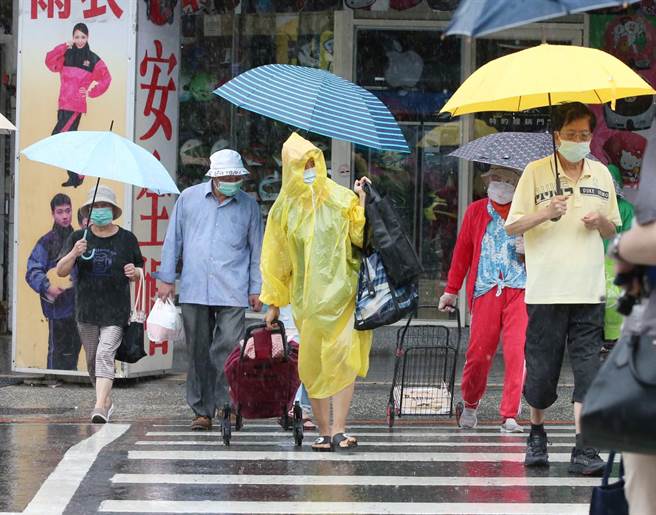 热低压、西南季风为全台带来豪雨，民眾冒雨出门。（赵双杰摄）