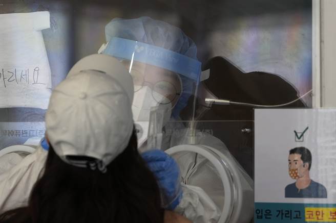 南韩全罗道木浦市3日传出2名确诊的大学生，即使没有接触到确诊者，也没有拿下口罩或饮食，疑因坐在确诊者曾坐过的椅子而不幸确诊。图为南韩医疗人员为民眾採检。(图/美联社)