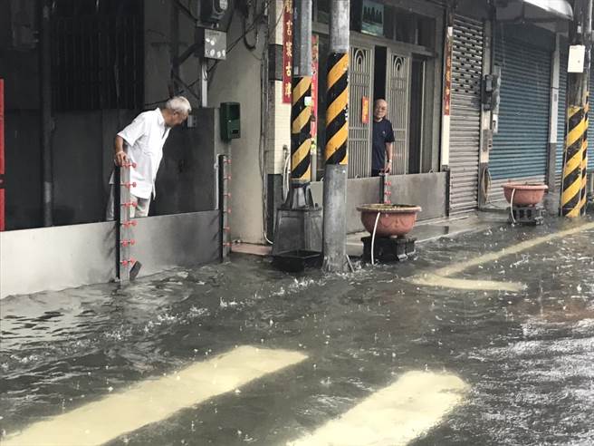 豪雨持续炸屏东，不少居民面临「我家门前有小河」的窘境，除挡水闸门连架3天不敢拆外，还有人清晨4点被雨声吵醒、急忙起床堆沙包。（谢佳潾摄）
