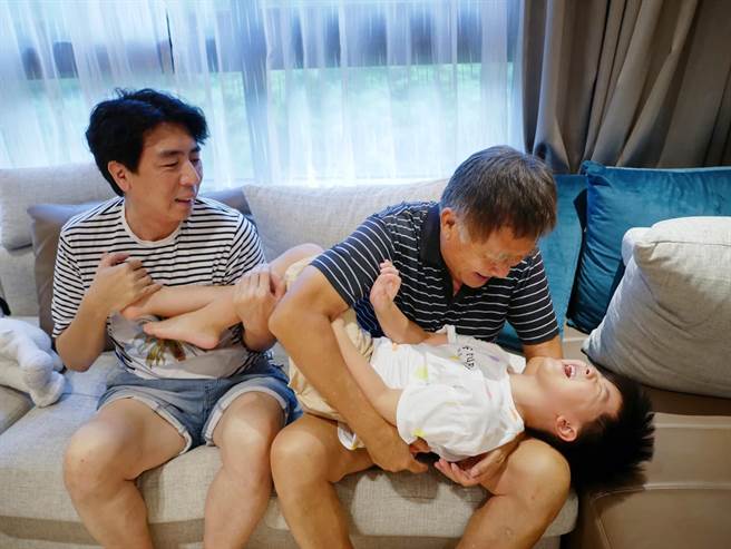 梁修身、梁赫群与孙子三代同乐。（梁赫群提供）