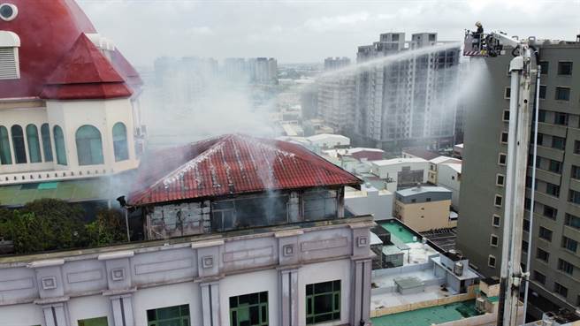 台中梧棲新天地8樓頂鐵皮加蓋倉庫失火，警消出動雲梯車從高空灑水灌救。（台中市消防局提供/王文吉台中傳真）