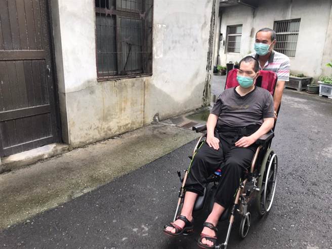 陈爸爸每天推着植物人儿子在巷弄间散步。（创世彰化分会提供／吴敏菁彰化传真）